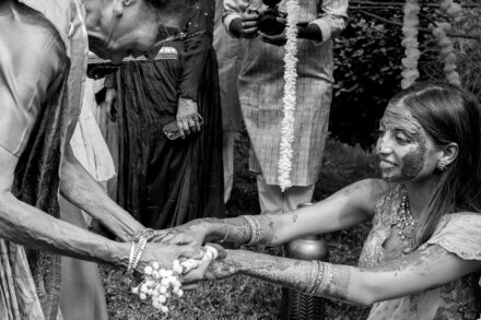 Family members laughing and covered in turmeric during Reeya and Neil’s Pithi ceremony in Rome.