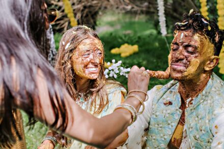 Hands covered in golden turmeric paste during the traditional Haldi ritual at Hotel Roma Life Style.