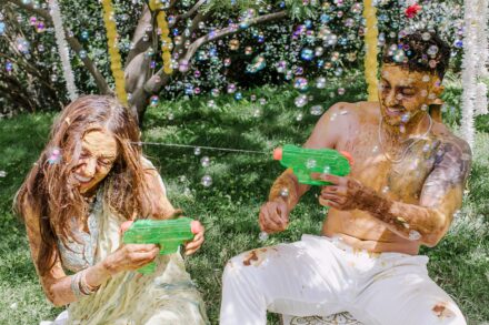 Guests playing with bubbles and enjoying the festive atmosphere during the Haldi celebration in Rome.