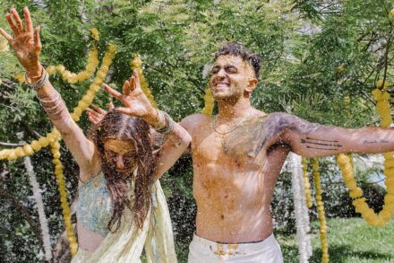 Reeya and Neil surrounded by friends and family, celebrating their Haldi in Rome with laughter and color.