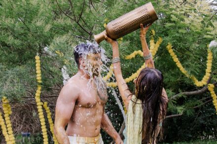 Reeya and Neil surrounded by friends and family, celebrating their Haldi in Rome with laughter and color.