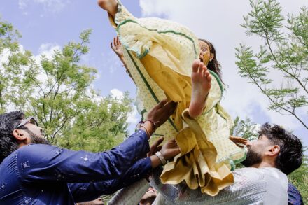 Guests joyfully lifting a participant during the Haldi ceremony in Rome, captured at Hotel Roma Life Style by Cossu Photography.