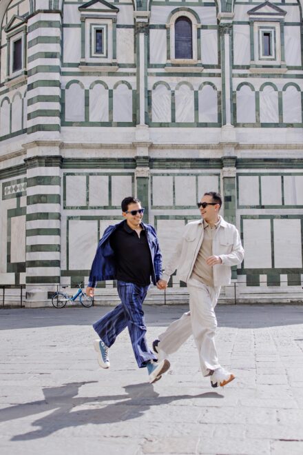 Lalo and Xavi walking hand in hand near the Florence Duomo during their pre-wedding photoshoot — elegant, cinematic and full of Tuscan light captured by Cossu Photography.