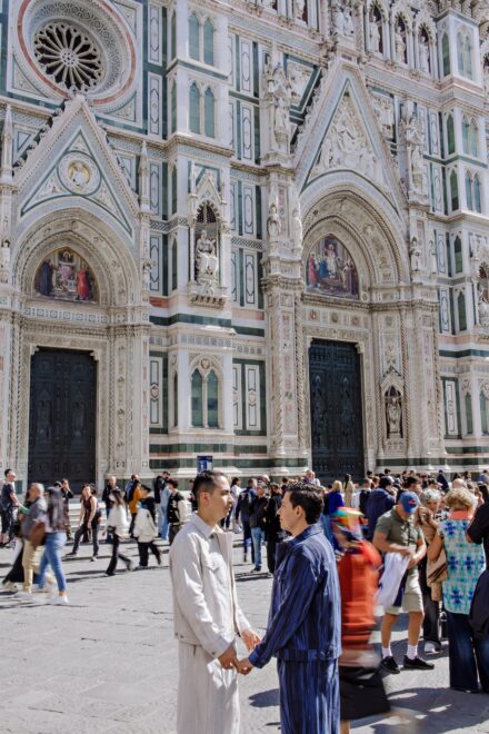 Lalo and Xavi walking hand in hand near the Florence Duomo during their pre-wedding photoshoot — elegant, cinematic and full of Tuscan light captured by Cossu Photography.