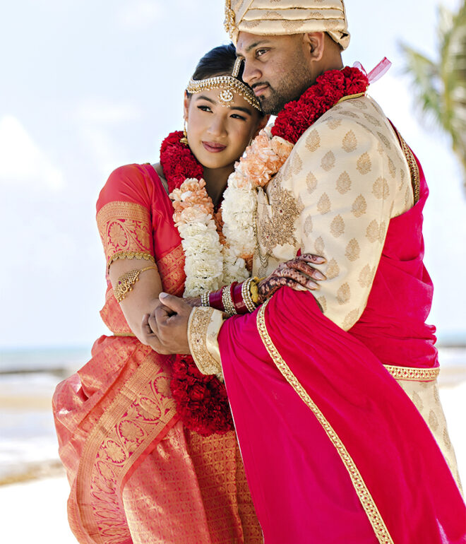 Indian bride and groom embracing on a beach in Italy during a Hindu destination wedding