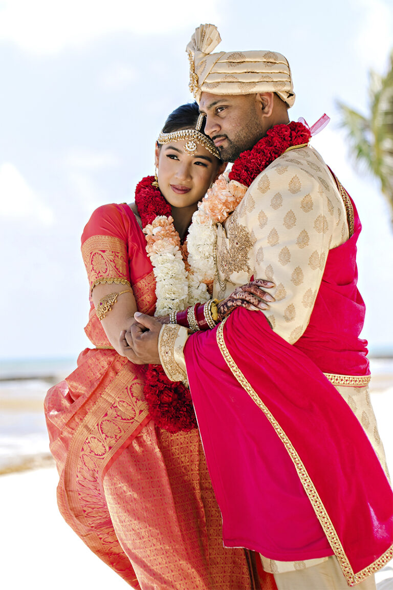 Indian bride and groom embracing on a beach in Italy during a Hindu destination wedding