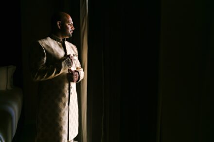 Indian groom getting ready by the window during a luxury Hindu wedding in Tuscany, Italy