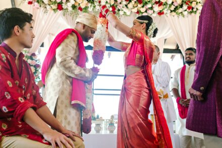 Indian bride and groom exchanging garlands during a Hindu wedding ceremony in Tuscany, Italy
