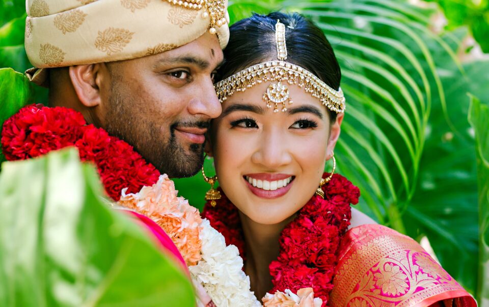 Indian bride and groom portrait surrounded by tropical greenery after their Hindu wedding in Riviera Maya, Mexico